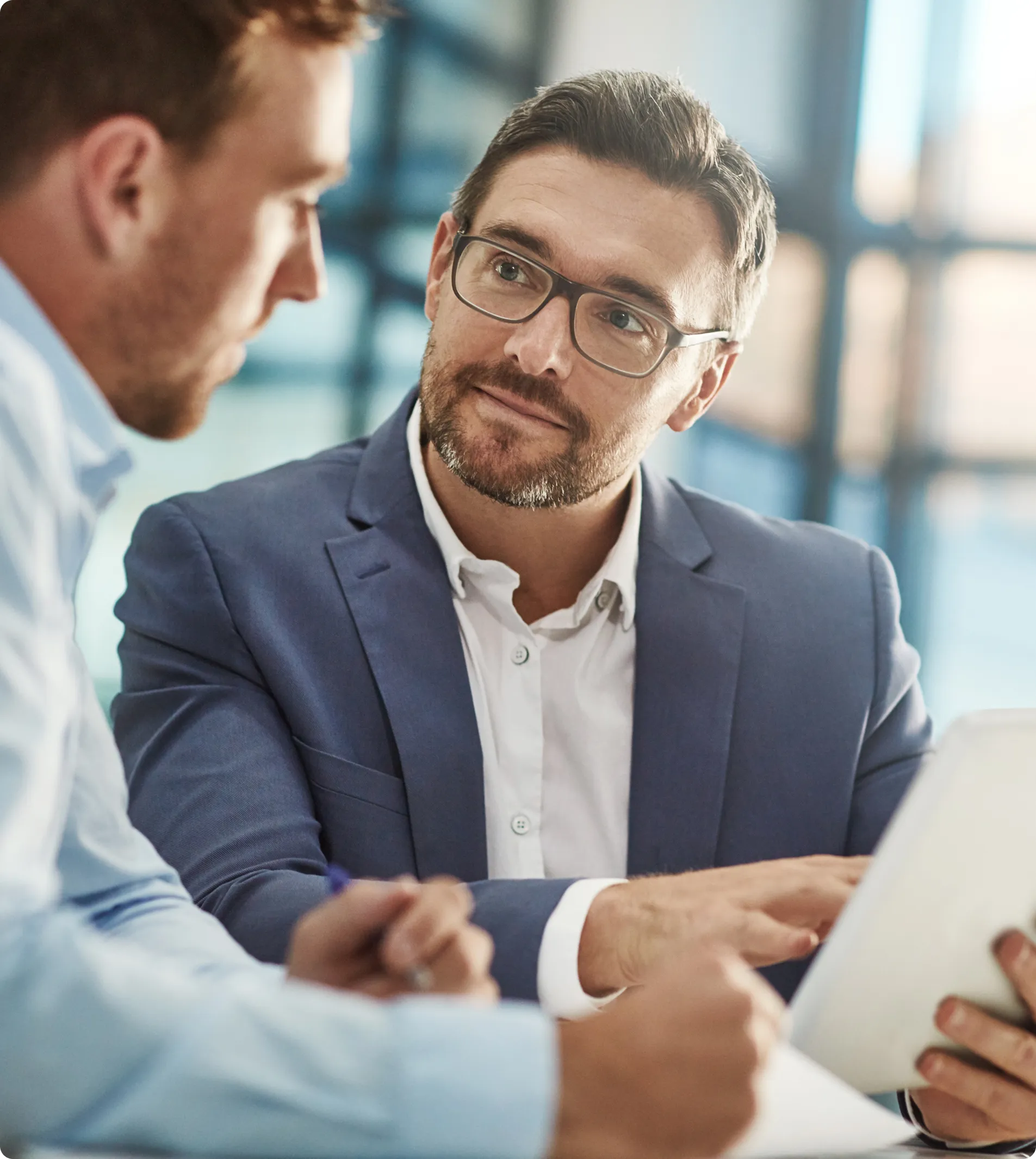 man in glassses shwoing paper to other colligue