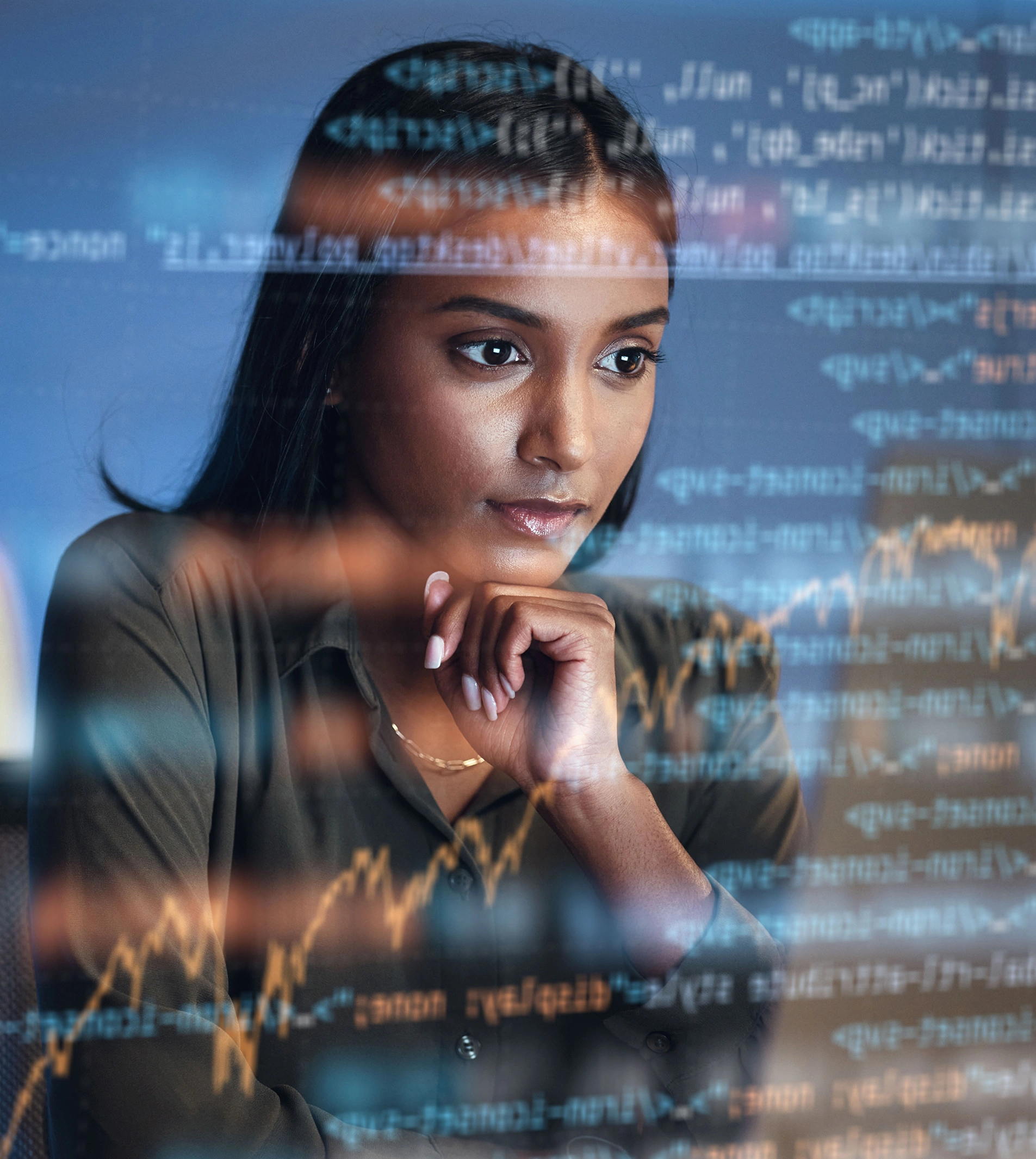 Three people sit around a table with charts, graphs, a laptop, a tablet, and a notebook, discussing data and business plans from printed documents spread out on the tabletop.