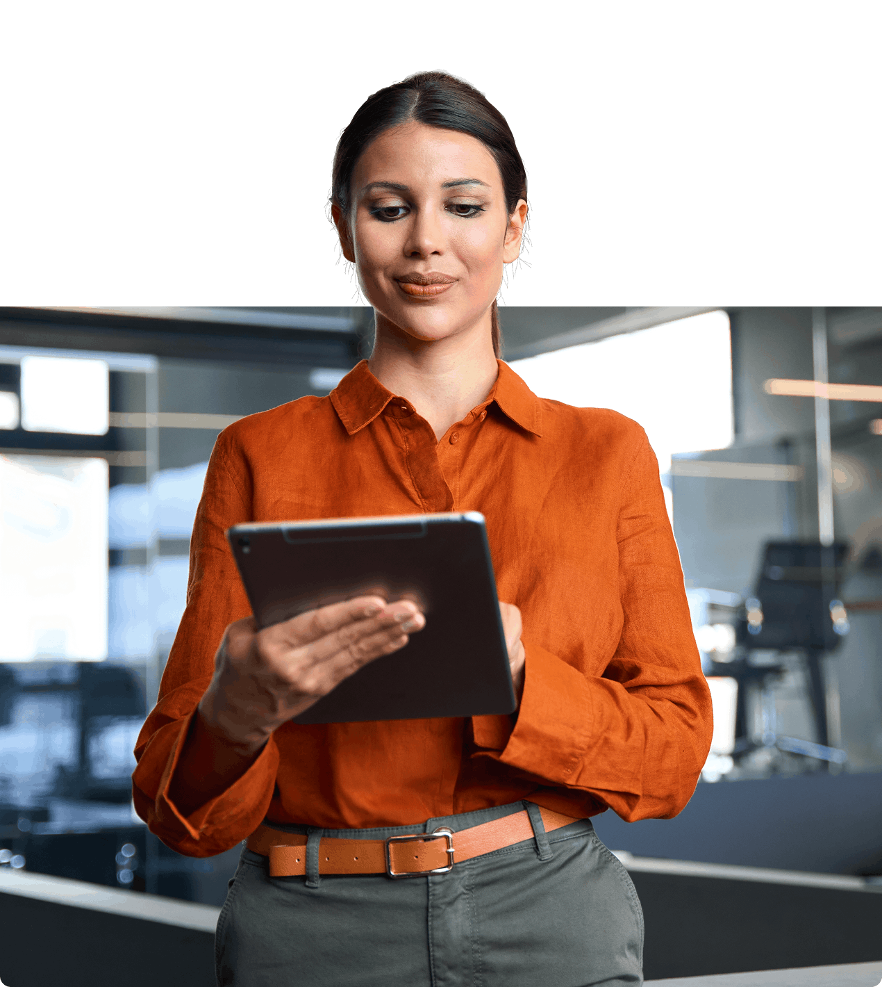 female in orange shirt face to camera standing and holding the tablet