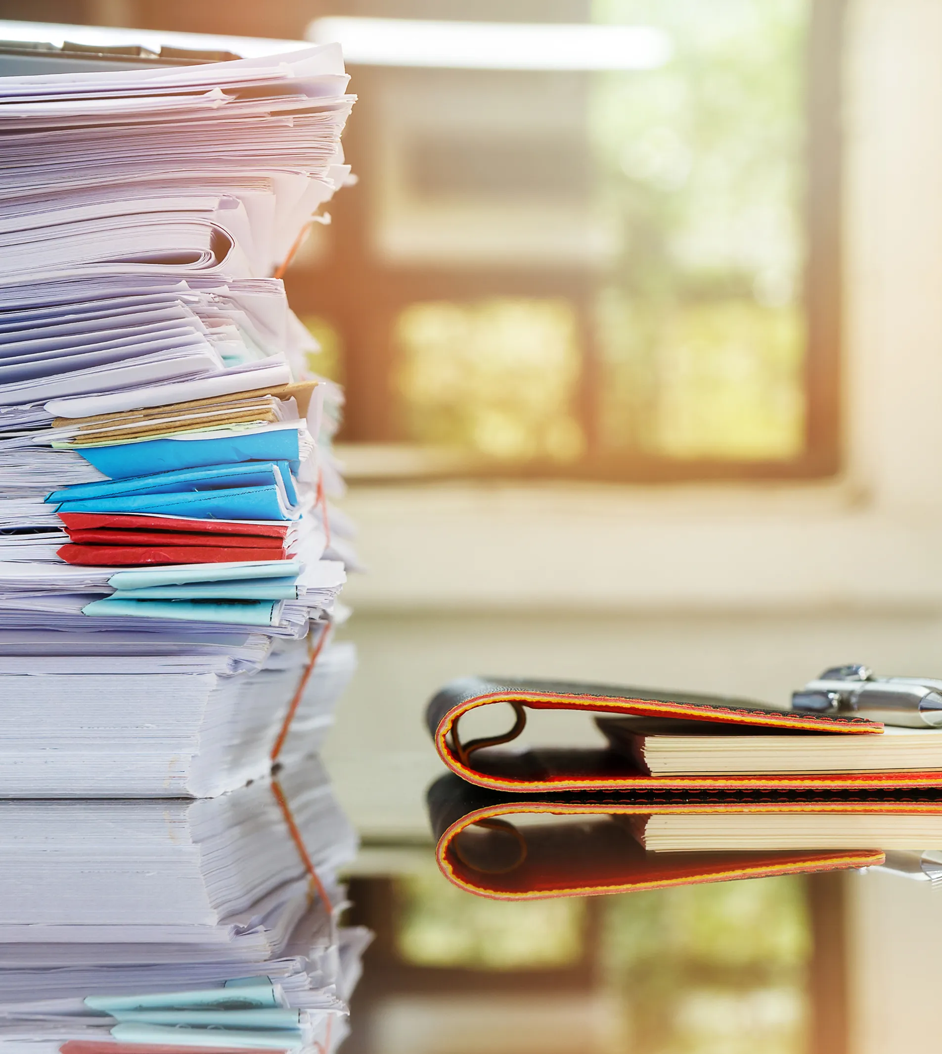 papers one above each other and a folder next to the papers